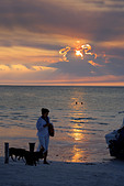 Woman walking dogs on the beach enjoying the sunset over Holbox island, Quintana Roo, Yucat�n Peninsula, Mexico,
